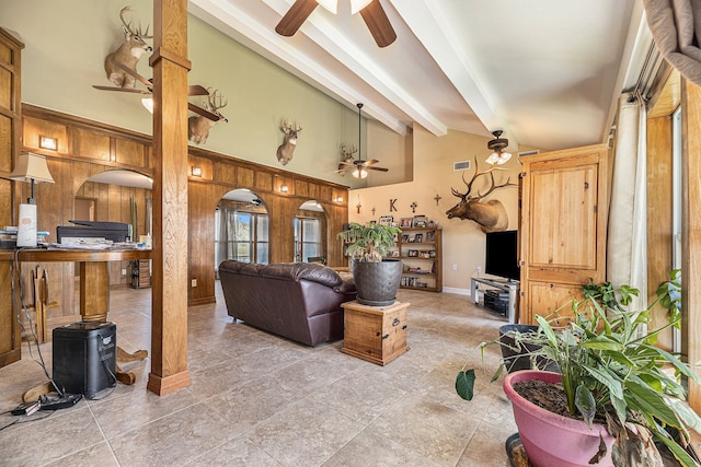 living room with lofted ceiling with beams and wood walls