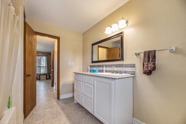 full bathroom featuring vanity and baseboards