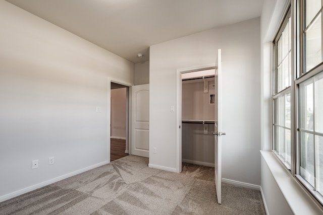 unfurnished bedroom featuring a closet, multiple windows, and carpet