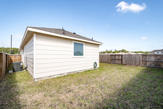 back of house featuring a yard and central air condition unit