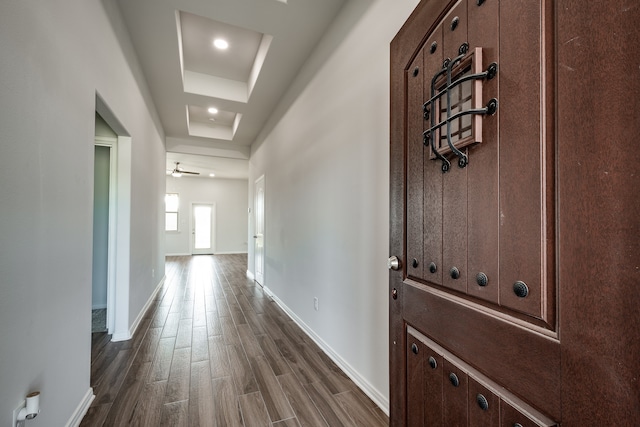 hall with dark hardwood / wood-style floors and a tray ceiling