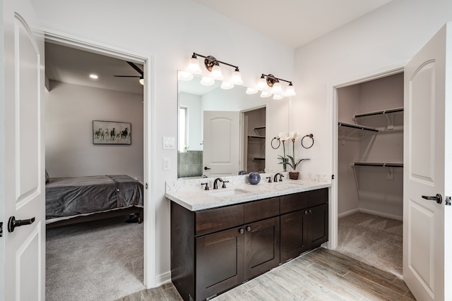 bathroom with wood-type flooring, double vanity, and ceiling fan