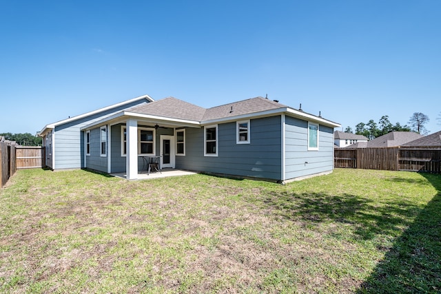 back of house featuring a lawn and a patio area