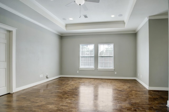 unfurnished room featuring ornamental molding, ceiling fan, a tray ceiling, and dark wood-type flooring