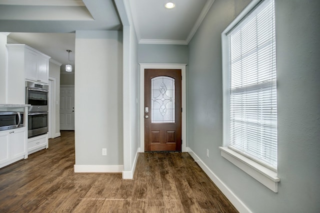 entrance foyer with dark hardwood / wood-style floors and ornamental molding