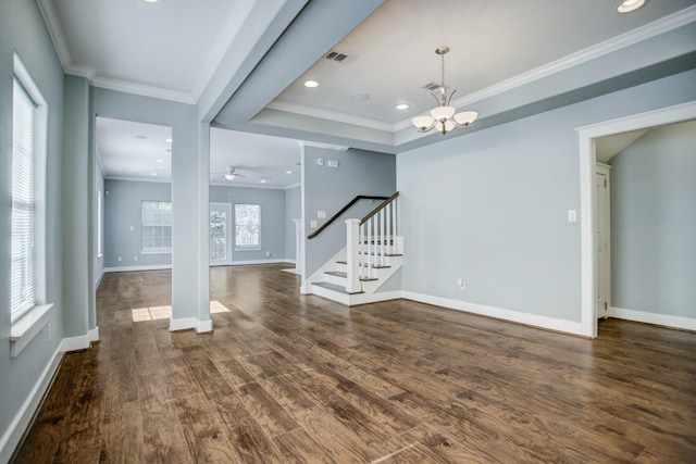 interior space featuring dark hardwood / wood-style flooring, crown molding, ceiling fan with notable chandelier, and a tray ceiling