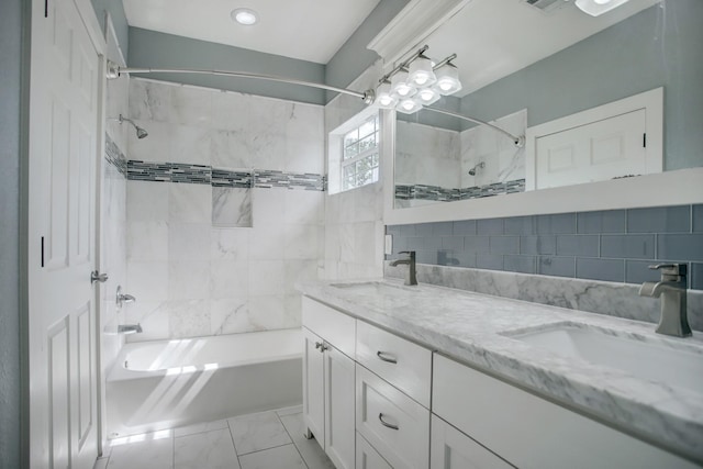 bathroom featuring tiled shower / bath, tile walls, backsplash, tile floors, and dual bowl vanity