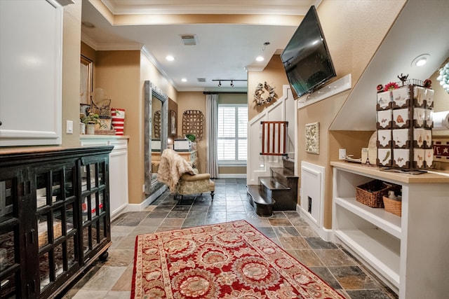 living area with rail lighting and ornamental molding