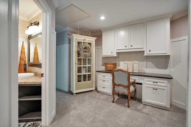 home office featuring light carpet, sink, built in desk, and ornamental molding