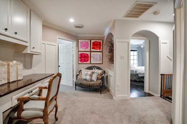 interior space featuring light colored carpet and crown molding