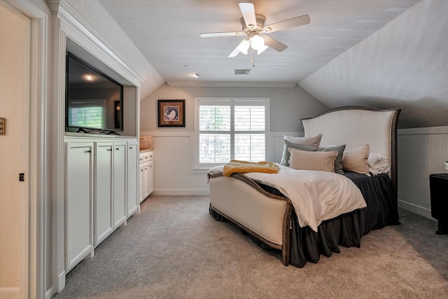 carpeted bedroom featuring ceiling fan, a textured ceiling, and vaulted ceiling