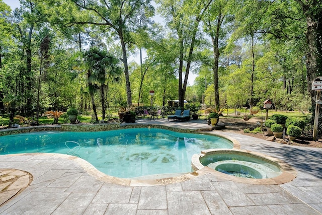 view of swimming pool featuring an in ground hot tub and a patio