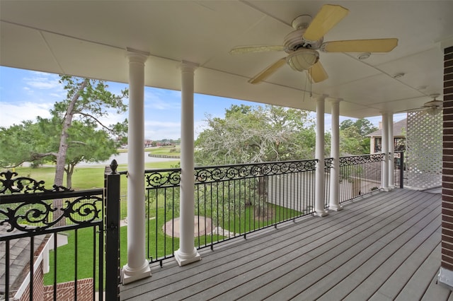 wooden terrace featuring ceiling fan and a yard