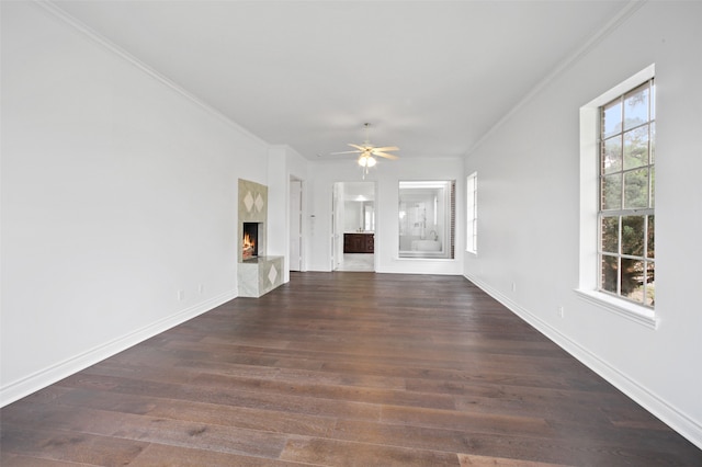 unfurnished living room with ornamental molding, dark wood-type flooring, and a premium fireplace