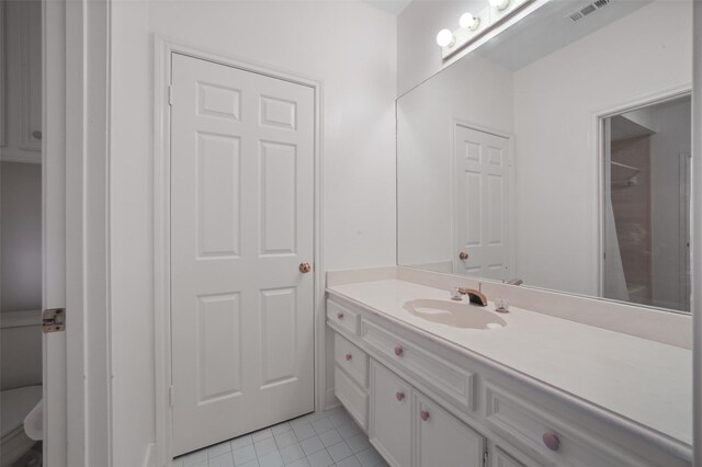 bathroom featuring tile patterned flooring, vanity, and toilet