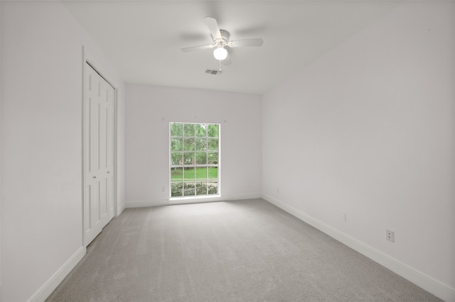 unfurnished bedroom featuring ceiling fan, a closet, and carpet floors