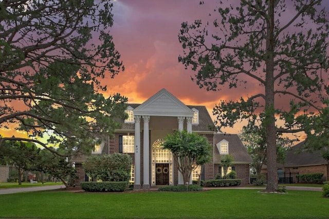 neoclassical / greek revival house featuring a yard