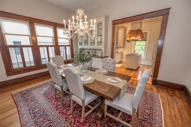 dining room featuring a chandelier, baseboards, and light wood-style flooring