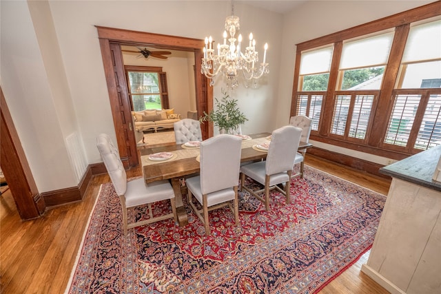 dining room featuring wood-type flooring and ceiling fan with notable chandelier