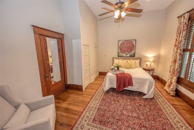 bedroom featuring light hardwood / wood-style flooring, ceiling fan, and lofted ceiling