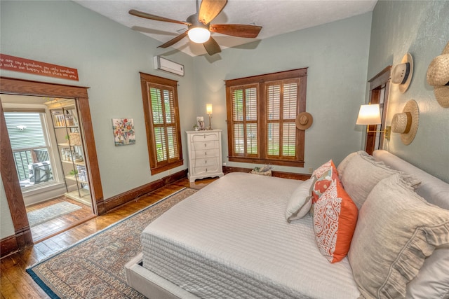 bedroom with access to exterior, ceiling fan, baseboards, an AC wall unit, and wood-type flooring