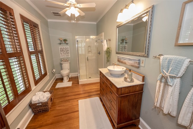 bathroom with hardwood / wood-style floors, vanity, a shower with door, crown molding, and toilet