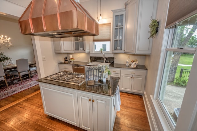 kitchen featuring white cabinetry, sink, light hardwood / wood-style flooring, custom exhaust hood, and appliances with stainless steel finishes