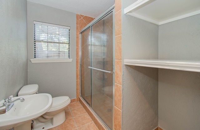 bathroom with tile flooring, walk in shower, sink, and toilet