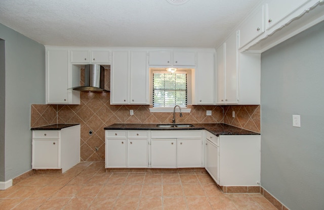 kitchen with sink, white cabinets, and wall chimney exhaust hood