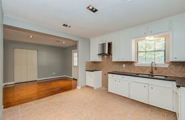 kitchen featuring a healthy amount of sunlight, wall chimney range hood, and light tile floors