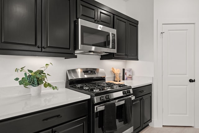 kitchen featuring appliances with stainless steel finishes, light stone counters, and light tile patterned floors