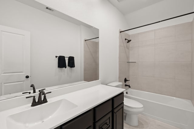 full bathroom featuring tile patterned flooring, tiled shower / bath, toilet, and vanity