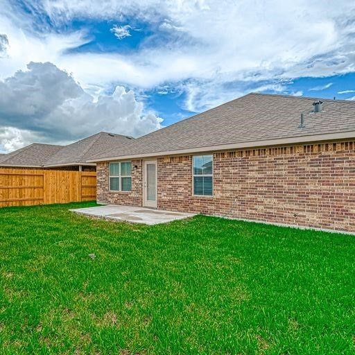 back of house featuring a patio and a yard