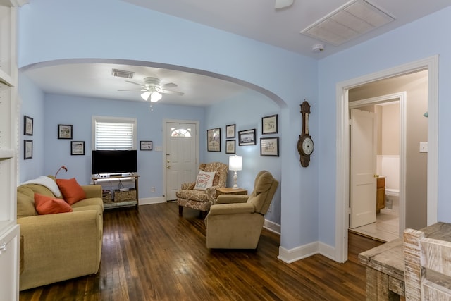 living room with ceiling fan and dark hardwood / wood-style flooring