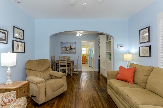 living room featuring ceiling fan and dark wood-type flooring