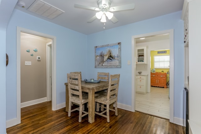 dining room with ceiling fan and dark wood-type flooring