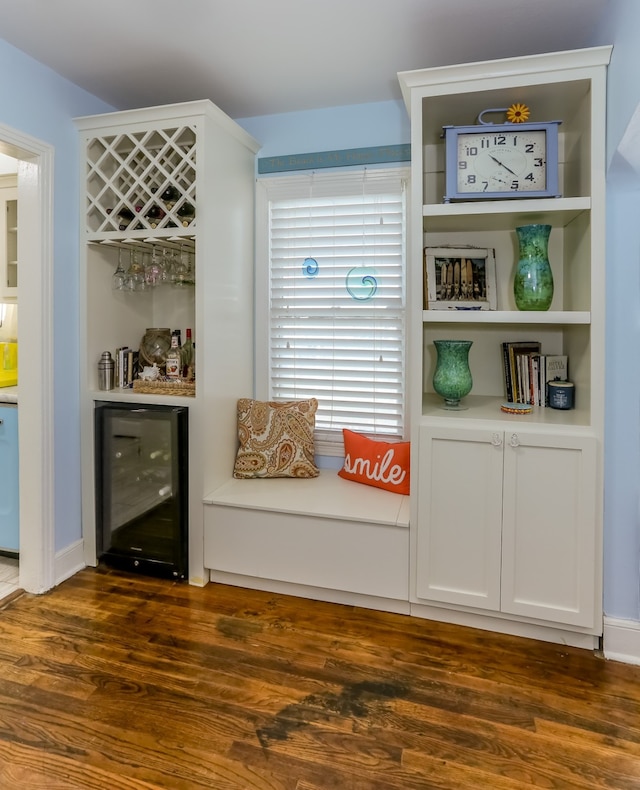 bar featuring wine cooler, white cabinets, and dark wood-type flooring