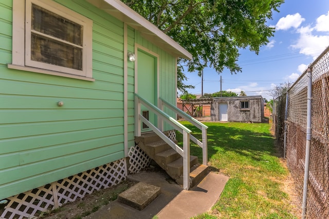 view of exterior entry with a lawn