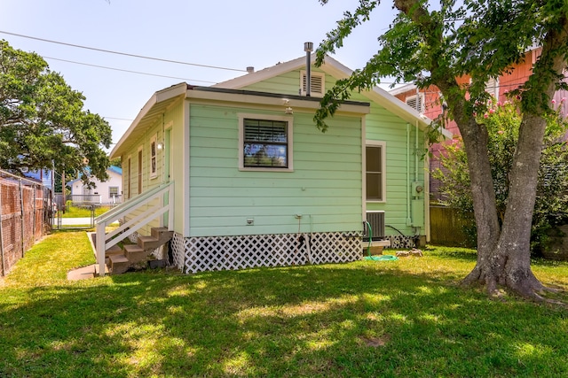 back of house featuring central AC and a yard