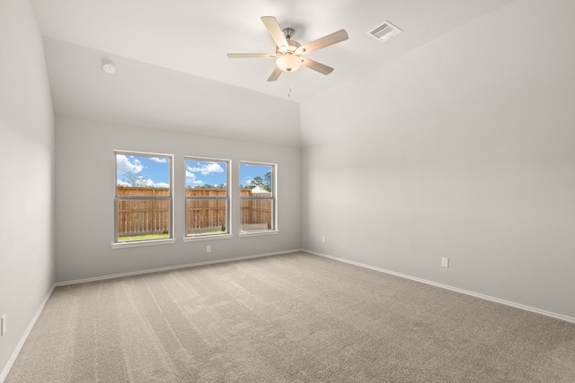 carpeted spare room featuring vaulted ceiling and ceiling fan