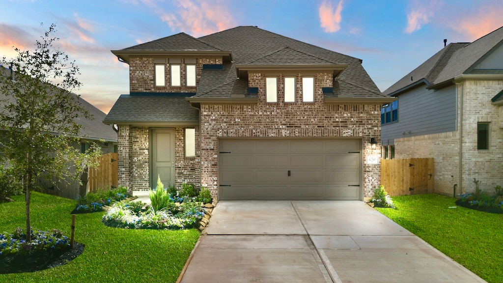 view of front of property featuring a garage and a lawn