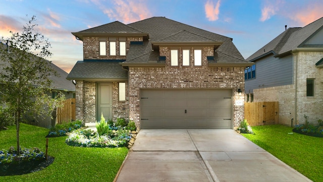 view of front of property featuring a garage and a lawn