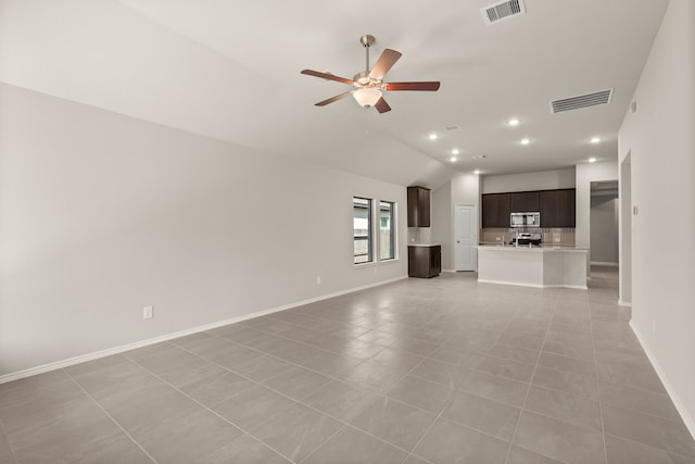 unfurnished living room with ceiling fan, vaulted ceiling, and light tile patterned flooring