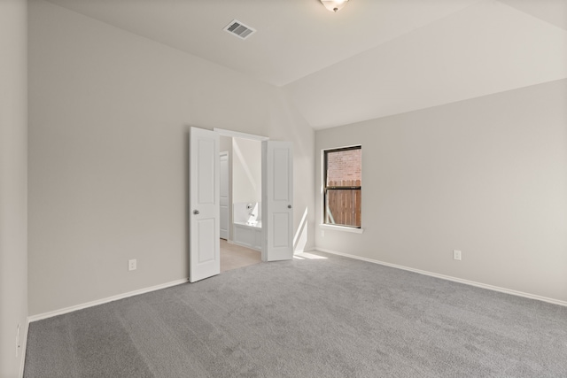 spare room with lofted ceiling and light carpet