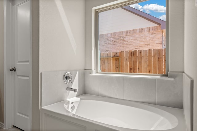 bathroom featuring a tub to relax in and plenty of natural light