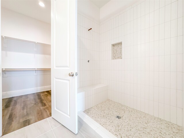 bathroom with tile patterned flooring and a tile shower