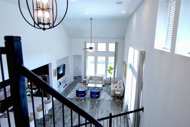 interior space with high vaulted ceiling and ceiling fan with notable chandelier