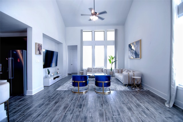 living room featuring high vaulted ceiling, dark hardwood / wood-style flooring, ceiling fan, and a wealth of natural light