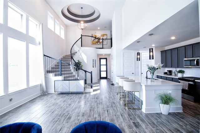 interior space with a raised ceiling, dark hardwood / wood-style flooring, a towering ceiling, and sink