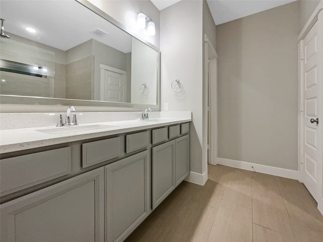 bathroom with hardwood / wood-style flooring and dual bowl vanity